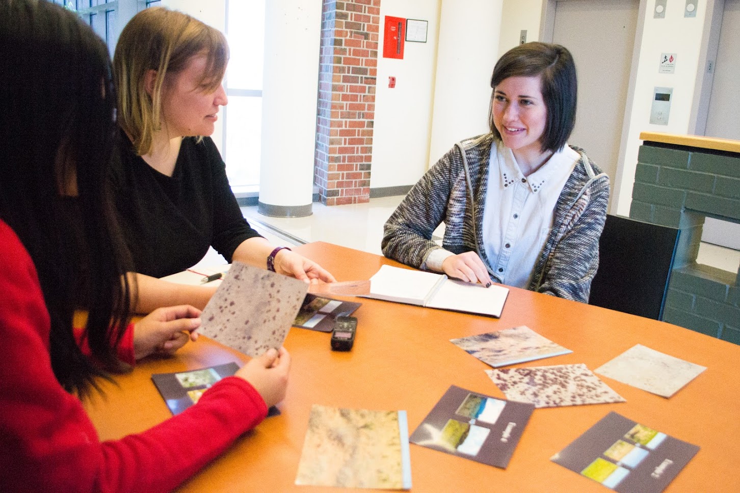 three people looking at research materials
